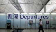FILE PHOTO: An airport security guard walks past a sign at the departure hall of Hong Kong Airport June 23, 2013. REUTERS/Bobby Yip POLITICS)//File Photo
