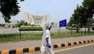 FILE PHOTO: A man walks past the Supreme Court building in Islamabad, Pakistan, June 27, 2016. REUTERS/Faisal Mahmood/File Photo
