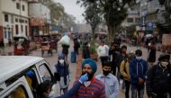 A healthcare worker collects a coronavirus disease (COVID-19) test swab sample from a man as others wait, amidst the spread of the disease, at a market area, in the old quarters of Delhi, India, January 7, 2022. REUTERS/Adnan Abidi
