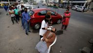 A healthcare worker collects a swab sample from a woman as others wait for their turn during a rapid antigen testing drive for the coronavirus disease (COVID-19) at a roadside in Ahmedabad, India, January 5, 2022. REUTERS/Amit Dave

