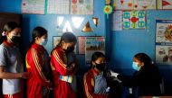 Students wait in a queue as their friend receives a dose of the Moderna vaccine at their school against the coronavirus disease (COVID-19), during a vaccination drive for children aged 12-17 in Bhaktapur, Nepal, January 9, 2022. REUTERS/Navesh Chitrakar
 