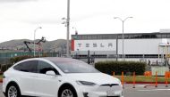 A Tesla vehicle drives past Tesla's primary vehicle factory after CEO Elon Musk announced he was defying local officials' coronavirus disease (COVID-19) restrictions by reopening the plant in Fremont, California, U.S. May 11, 2020. REUTERS/Stephen Lam


