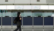 FILE PHOTO: A woman walks past empty counters of Cathay Pacific at Hong Kong International Airport following fresh measures to control coronavirus (COVID-19) infections in Hong Kong, China January 11, 2022. REUTERS/Lam Yik/File Photo
