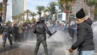Demonstrators are hit by a water cannon during a protest against Tunisian President Kais Saied's seizure of governing powers, in Tunis, Tunisia, January 14, 2022. REUTERS/