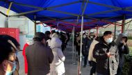 People line up to take nucleic acid tests at a testing site outside a hospital, following a new confirmed case of the coronavirus disease (COVID-19), in Beijing, China January 16, 2022. REUTERS/Yew Lun Tian