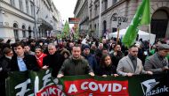 People hold signs during a protest against coronavirus disease (COVID-19) measures and vaccinations in front of the Ministry of Human Capacities, in Budapest, Hungary, January 16, 2022. REUTERS/Marton Monus
