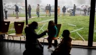 A mother administers a COVID-19 saliva test to her child as people stand in a queue at a coronavirus disease (COVID-19) testing centre in Saint-Hilaire-de-Loulay near Nantes, France, January 17, 2022. REUTERS/Stephane Mahe
