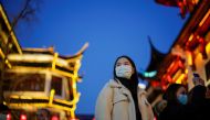 People wearing protective masks walk by an area decorated with lanterns ahead of the Chinese Lunar New Year festivity at Yu Garden, following new coronavirus disease (COVID-19) cases in Shanghai, China January 18, 2022. Reuters/Aly Song