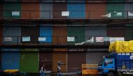People walk past closed shops at a market area after authorities in the capital ordered a weekend curfew, following the rise in the coronavirus disease (COVID-19) cases, in the old quarters of Delhi, India, January 8, 2022. REUTERS/Adnan Abidi

