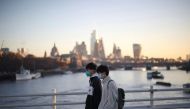 People wearing protective face masks walk over Waterloo Bridge during morning rush hour, amid the ongoing coronavirus disease (COVID-19) pandemic in London, Britain, January 21, 2022. REUTERS/Henry Nicholls


