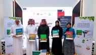 Officials showing copies of The Encyclopedia of Native & Non-Native Plants in Eastern Arabia during the launch ceremony at Doha International Book Fair.