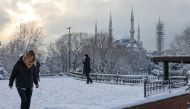 Tourists walk along Sultanahmet Square as Sultan Ahmet mosque, popularly known as the Blue Mosque, is seen in the background during a snowy day in Istanbul, Turkey, January 24, 2022. REUTERS/Umit Bektas
