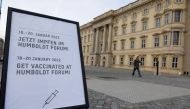 A sign displaying the dates that a pop-up vaccination centre is open is seen, as a person walks outside the coronavirus disease (COVID-19) vaccination centre in the Humboldt Forum, in Berlin, Germany January 19, 2022. REUTERS/Michele Tantussi

