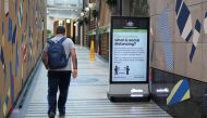 A man walks in a corridor near a sign with instructions about the coronavirus and social distancing following the implementation of stricter social-distancing and self-isolation rules to limit the spread of the coronavirus disease (COVID-19) in Sydney, Australia, March 31, 2020. REUTERS/Loren Elliott

