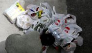 A woman packs her grocery shopping as she stocks up on food supplies, after Singapore raised coronavirus outbreak alert level to orange, outside a supermarket in Singapore February 8, 2020. REUTERS/Edgar Su/File Photo

