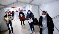 FILE PHOTO: People wait to get a dose of the vaccine against the coronavirus disease (COVID-19), on the day Italy brings in tougher rules for the unvaccinated, at a Red Cross vaccination centre by Termini main train station in Rome, Italy, January 10, 2022. REUTERS/Guglielmo Mangiapane//File Photo
