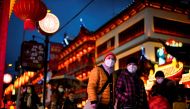 People wearing protective masks walk by an area decorated with lanterns ahead of the Chinese Lunar New Year festivity, following new coronavirus disease (COVID-19) cases in Shanghai, China January 28, 2022. REUTERS/Aly Song
