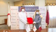 Ali bin Hassan Al Hammadi, Secretary-General of QRCS, and Sultan bin Hassan Al Jamali, Secretary General of NHRC, exchanging document after signing the agreement.