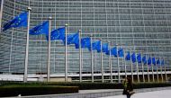 A woman walks outside of the European Commission's Berlaymont building in Brussels, Belgium