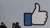 FILE PHOTO: People stand in front of the entrance sign to Facebook headquarters in Menlo Park, California, U.S. October 27, 2021. REUTERS/Carlos Barria/File Photo
