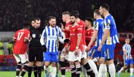 Players surround referee Peter Bankes as he initially gives Brighton & Hove Albion's Lewis Dunk a yellow card before changing it to a red card after looking at the VAR monitor REUTERS/Peter Powell 