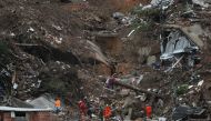 Rescue workers carry the body of a victim at the site of a mudslide at Morro da Oficina, following heavy rainfall in Petropolis, Brazil February 18, 2022. REUTERS/Ricardo Moraes