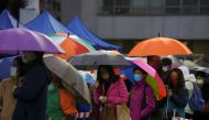People queue in the rain at a makeshift testing centre for the coronavirus disease (COVID-19) in Hong Kong, China February 20, 2022. REUTERS/Lam Yik