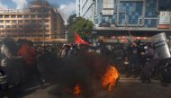 A demonstrator throws a burning tire towards the riot police during a protest against the $500 million U.S infrastructure grant under the Millennium Challenge Corporation (MCC) near the parliament in Kathmandu, Nepal February 20, 2022. REUTERS/Navesh Chitrakar