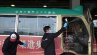 Cleaning staff spray disinfectant on a public minibus for driving coronavirus disease (COVID-19) patients, in Hong Kong, China February 21, 2022. REUTERS/Lam Yik/File Photo