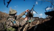 A Ukrainian service member holds a machine gun in a trench at a position on the front line near the village of Travneve in Donetsk region, Ukraine February 21, 2022. Reuters/Gleb Garanich

