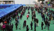 People wearing face masks line up at a testing centre for the coronavirus disease (COVID-19) in Hong Kong, China February 23, 2022. REUTERS/Lam Yik