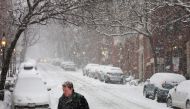 A pedestrian walks through falling snow during a winter storm in Boston, Massachusetts, U.S., February 25, 2022. REUTERS/Brian Snyder