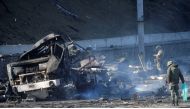 Ukrainian servicemen inspect a damaged vehicle, at the site of fighting with Russian troops, after Russia launched a massive military operation against Ukraine, in Kyiv, Ukraine February 26, 2022. REUTERS/Valentyn Ogirenko