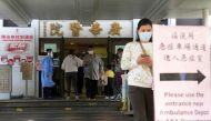 People walk at the entrance of a hospital, following the coronavirus disease (COVID-19) outbreak, in Hong Kong, China February 11, 2022. REUTERS/Lam Yik/File Photo