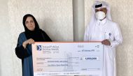 Al Dana Qatar National Day draw winner with Doha Bank official.