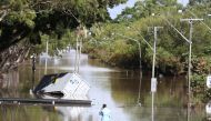 A man stands in front of a flooded street following heavy rains in Lismore, New South Wales, Australia March 2, 2022. AAP Image/Jason O'Brien via REUTERS