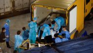 Corpses are moved to a refrigerated container outside a funeral home, as mortuaries run out of space amid the coronavirus disease (COVID-19) outbreak in Hong Kong, China, March 5, 2022. REUTERS/Tyrone Siu