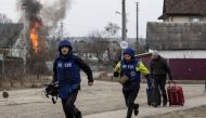 Journalists run for cover after heavy shelling on the only escape route used by locals, while Russian troops advance towards the capital, in Irpin, near Kyiv, Ukraine March 6, 2022. REUTERS/Carlos Barria
