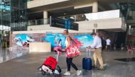 Foreign tourists carrying their luggage walk as they arrive at the I Gusti Ngurah Rai International Airport, as the local government kicks off the first day of the 'quarantine free' trial, amid the coronavirus disease (COVID-19) pandemic, in Bali, Indonesia, March 7, 2022. REUTERS/Sultan Anshori NO RESALES. NO ARCHIVES