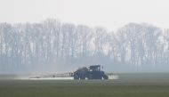 An agricultural worker drives a tractor spreading fertilizers to a field of winter wheat near the village of Husachivka in Kiev region, Ukraine April 17, 2020. REUTERS/Valentyn Ogirenko/File Photo