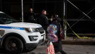 A woman walks with balloons by an area where NYPD police have marked off an area where a 43-year-old man was found dead on Sunday evening in New York City, U.S., March 14, 2022. REUTERS/Shannon Stapleton

