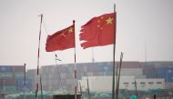 FILE PHOTO: Chinese flags flutter near containers stacked at the Yangshan Deep Water Port in Shanghai, China January 13, 2022. REUTERS/Aly Song