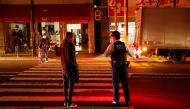 A police talks with a local resident on the street during an electric stoppage at the area after an earthquake in Tokyo, Japan March 17, 2022. REUTERS/Issei Kato
