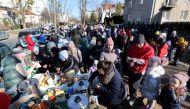Refugees eat as they wait in front of the Ukrainian consulate in Warszawa, Poland March 10, 2022. Kuba Atys/Agencja Wyborcza.pl via REUTERS
