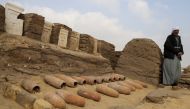 An archaeologist looks on after working outside a newly discovered tombs at the Saqqara area, in Giza, Egypt, March 19, 2022. REUTERS/Hanaa Habib