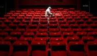 A worker wearing protective gear sprays disinfectant inside an empty PVR multiplex that was closed following the outbreak of the coronavirus disease (COVID-19), in New Delhi, India July 31, 2020. REUTERS/Adnan Abidi/File Photo