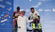 Qatar Motor and Motorcycle Federation Executive Director Amro Al Hamad presents the trophy to QSTK 600 champion Abdulla Al Qubaisi after the sixth and final round at the Losail International Circuit, yesterday. 
