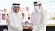 Omar Abdelaziz Al Meer, head (Business Development) at QIIB, receiving a commemorative shield from President of Qatar University, Dr. Hassan Rashid Al Derham during the event.