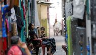 People sit outside to cool themselves from heat during the power cut as many parts of the country currently face long power cuts, as currency shortage makes fuel scarce, in Colombo, Sri Lanka March 31, 2022. REUTERS/Dinuka Liyanawatte



