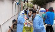 Medical workers in protective suits administer nucleic acid testing for residents in a residential compound in Shanghai, China April 1, 2022. Reuters/Brenda Goh